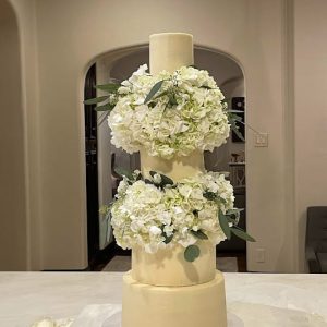 Gorgeous four tier white wedding cake with hydrangea clusters | Petite Sweets by Laura